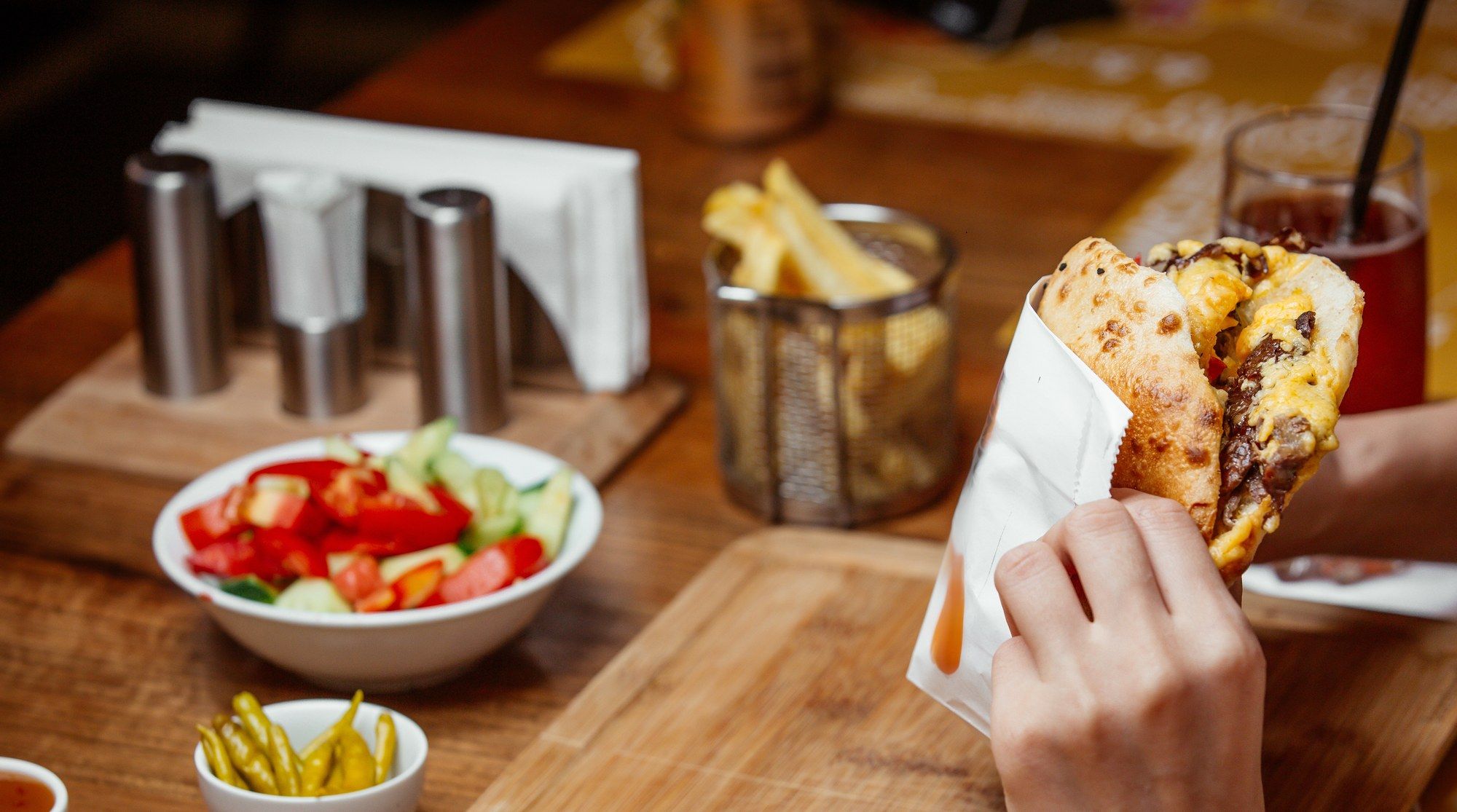 Döner im Brot auf einem Holzbrett mit Salat