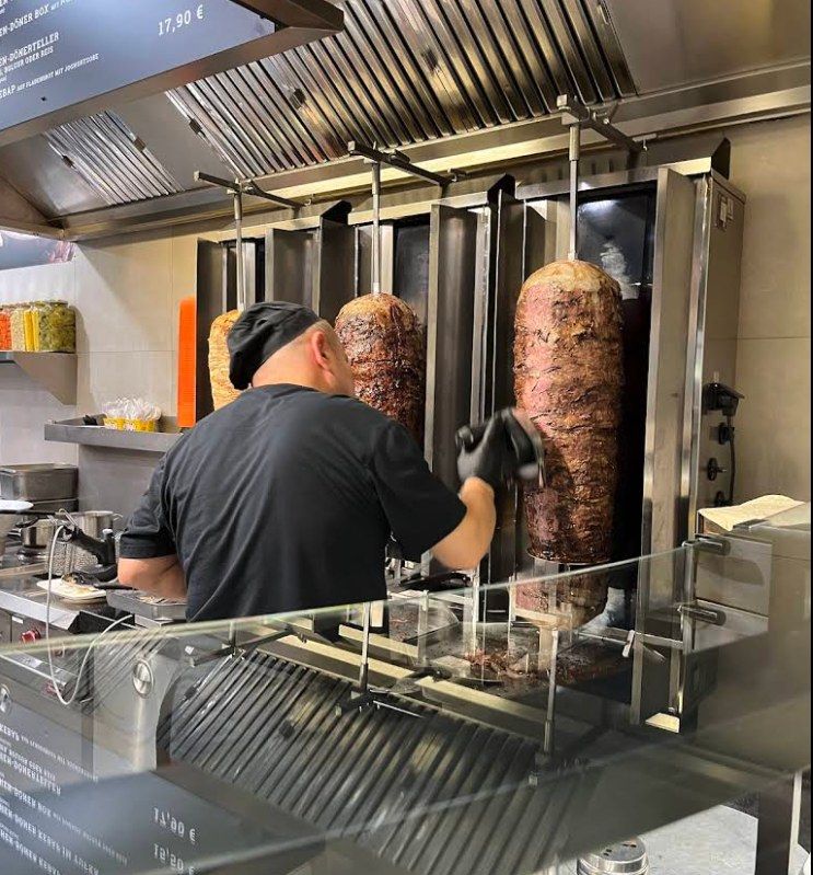 Mitarbeiter schneidet Döner frisch vom Spieß